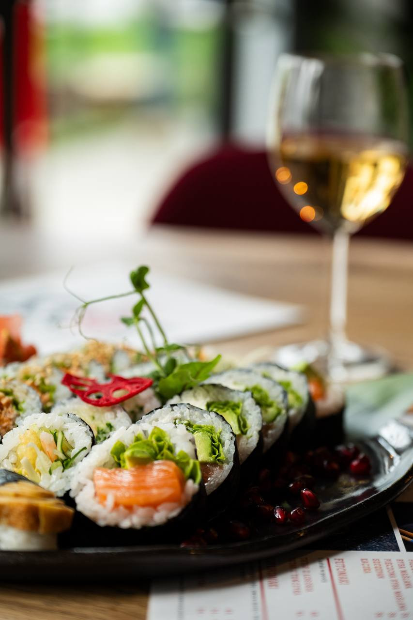 Rolki sushi i kieliszek białego wina